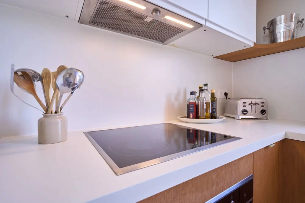 Cuisine, plan de travail blanc et façades en bois — Enghien-les-Bains, bord du lac